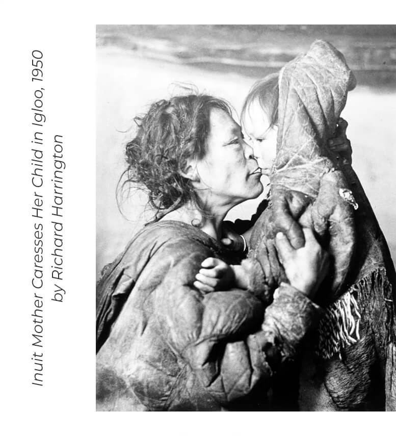 Inuit mother caresses her child in igloo